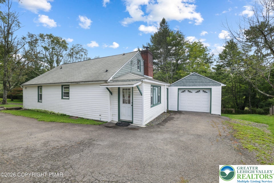 1207 Seese Hill Road Canadensis, PA 18325 - Photo 33 of 49 Mature trees frame a charming home featuring a paved driveway and detached garage storage.