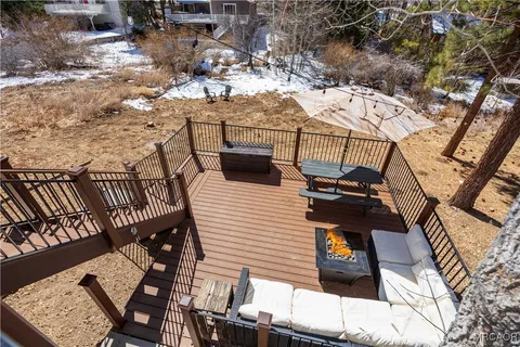 a view of a patio with table and chairs and potted plants and large trees