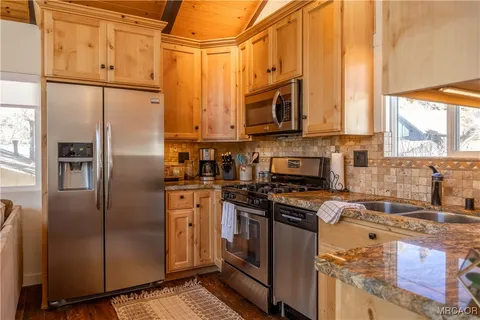 a kitchen with stainless steel appliances a stove a sink and a refrigerator