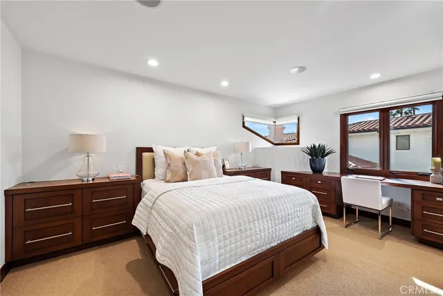 a bedroom with a bed a table and painting on the wall