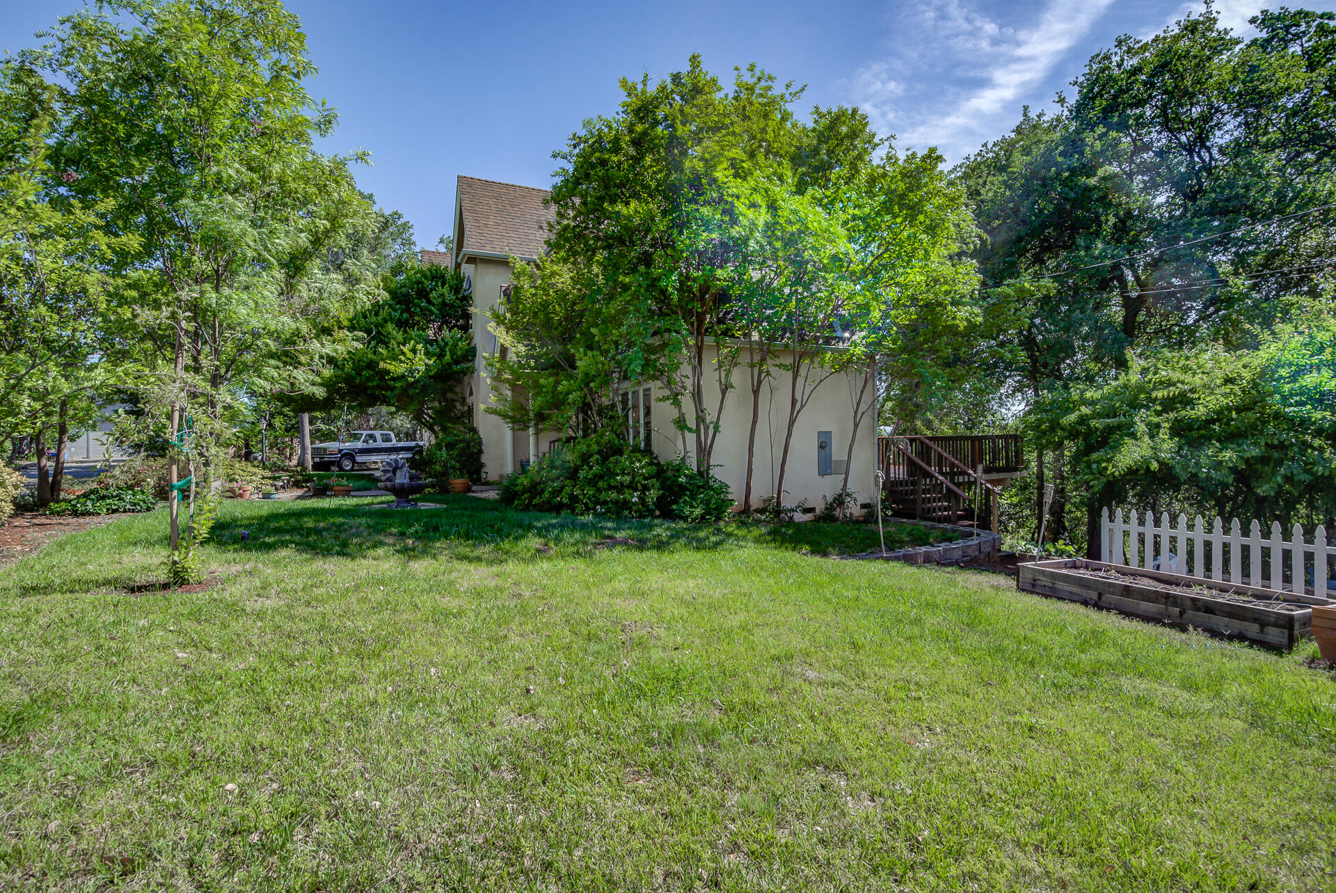 5146 Surrey Drive Redding, CA 96002 - Photo 46 of 57 a view of a backyard with potted plants and large trees