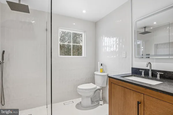 a bathroom with a toilet a sink and mirror