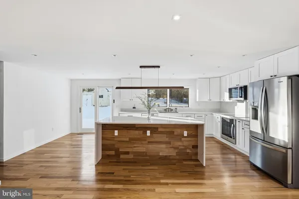a view of kitchen with wooden floor and electronic appliances