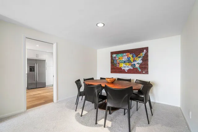 a dining room with furniture and a floor to ceiling window