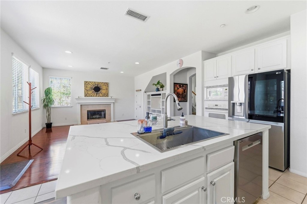 1663 Naranjo Court Redlands, CA 92374 - Photo 16 of 59 a kitchen with kitchen island a stove and a sink