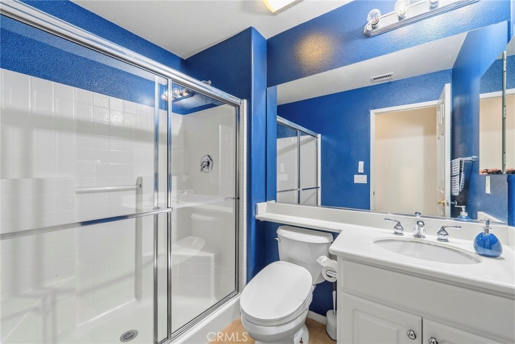 1663 Naranjo Court Redlands, CA 92374 - Photo 24 of 59 a bathroom with a toilet a sink and a large mirror