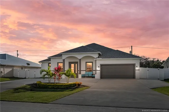 a front view of a house with a garden and garage