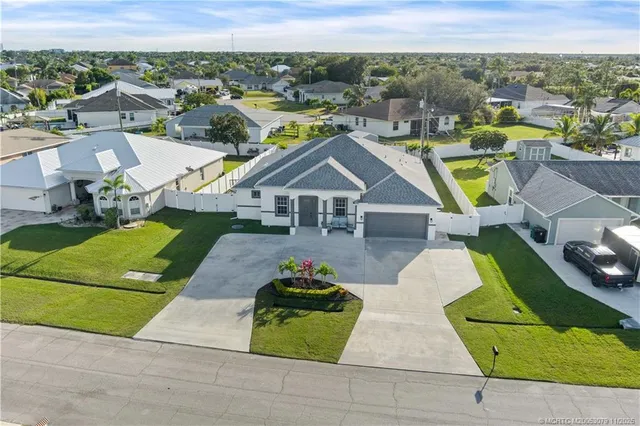 an aerial view of a house with a big yard and large trees