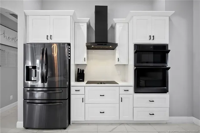 a kitchen with white cabinets and sink