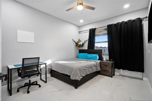 a bedroom with a bed window and a chair