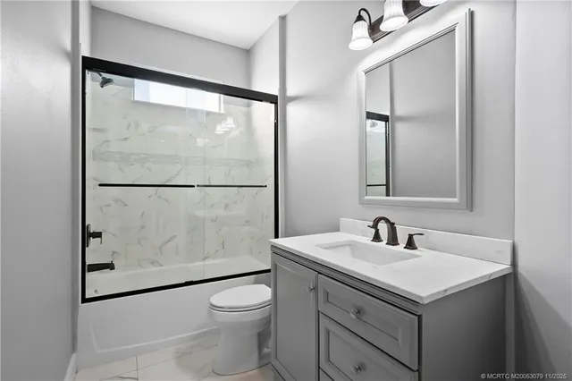 a bathroom with a sink mirror vanity and toilet