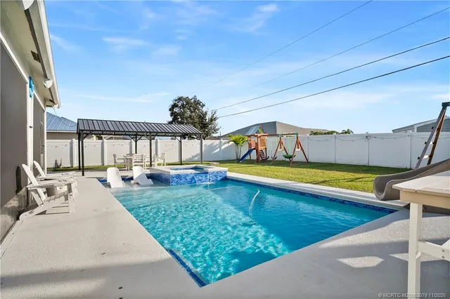 a view of swimming pool with seating area and barbeque oven