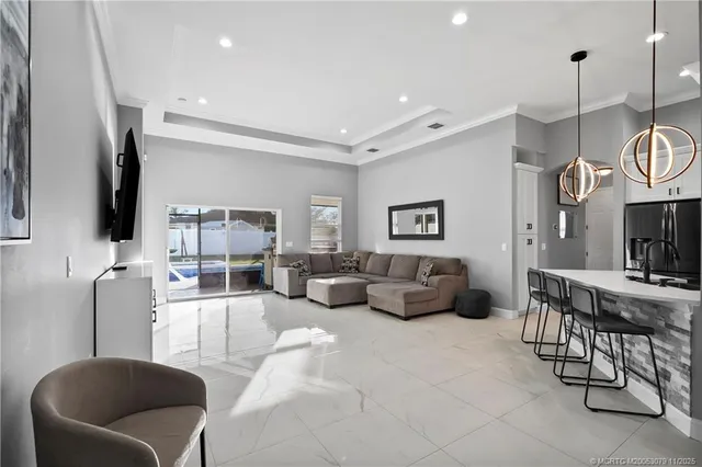 a living room with furniture kitchen view and a flat screen tv