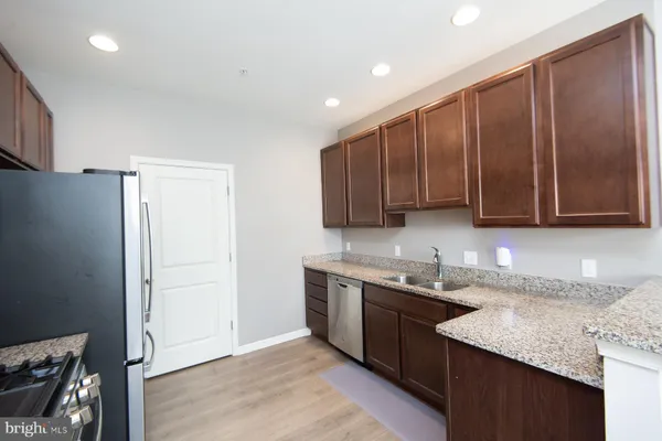 a kitchen with stainless steel appliances granite countertop a sink stove and refrigerator