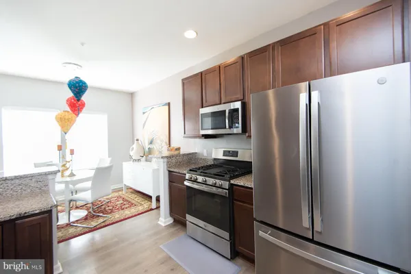 a kitchen with granite countertop a refrigerator and a stove top oven