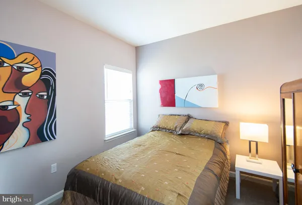 a bedroom with a bed and a painting on the wall