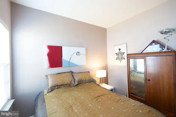 a bedroom with a bed and a painting on the wall