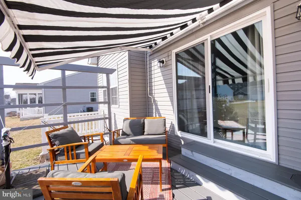 a view of a patio with couches table and chairs and wooden floor