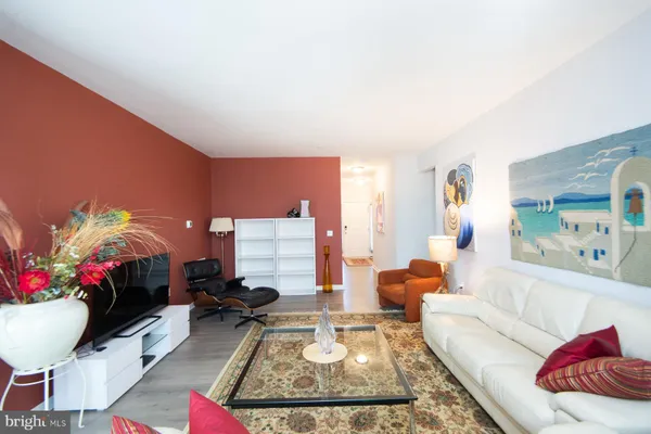 a living room with furniture potted plant and a large window