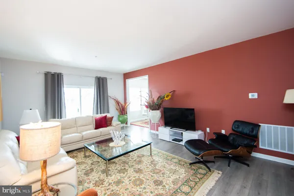a living room with furniture a rug and a flat screen tv