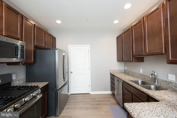 a kitchen with stainless steel appliances granite countertop a refrigerator stove and sink