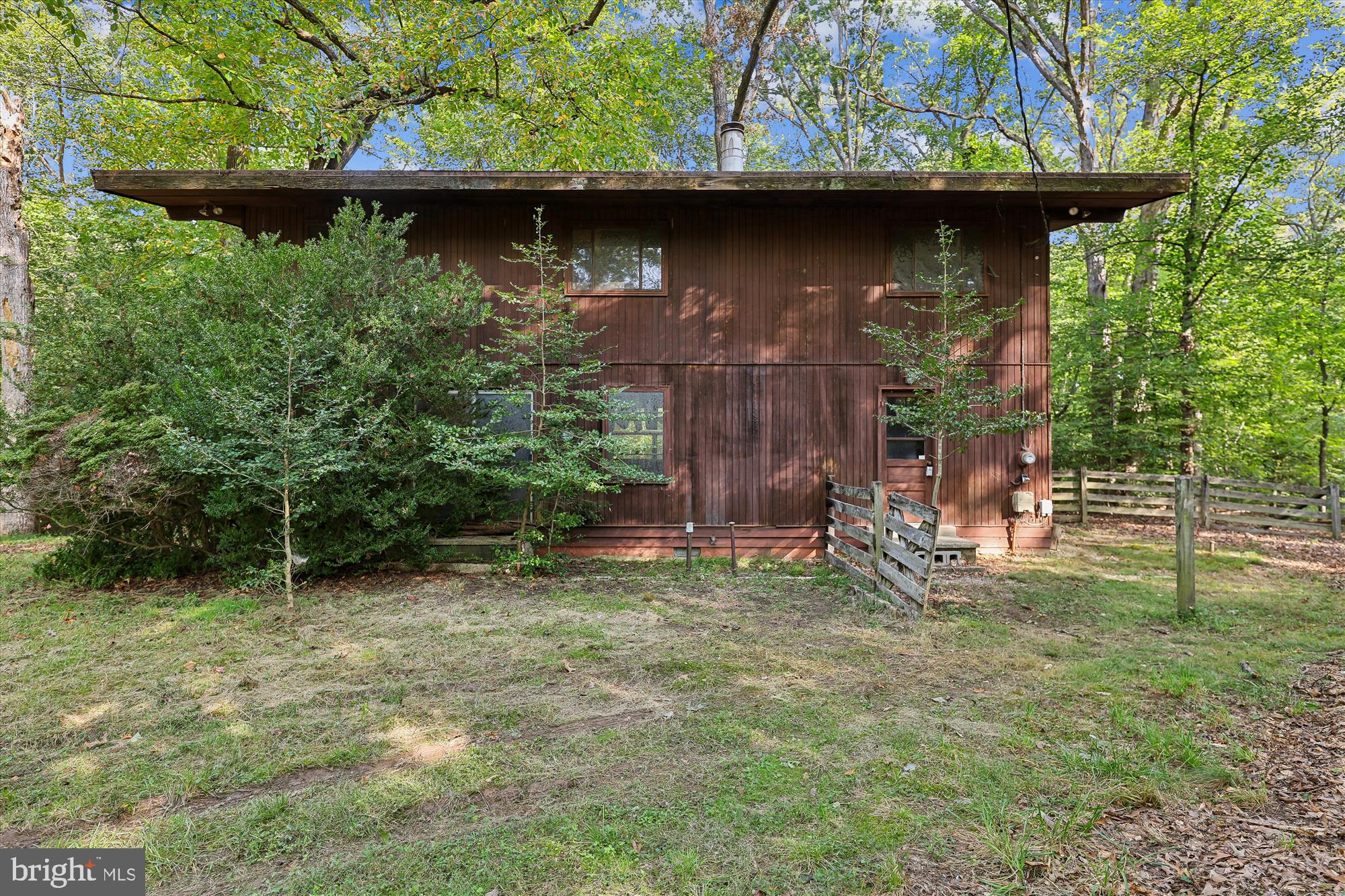 15120 Reserve Road Accokeek, MD 20607 - Photo 3 of 32 a view of a wooden house with a yard and a bench