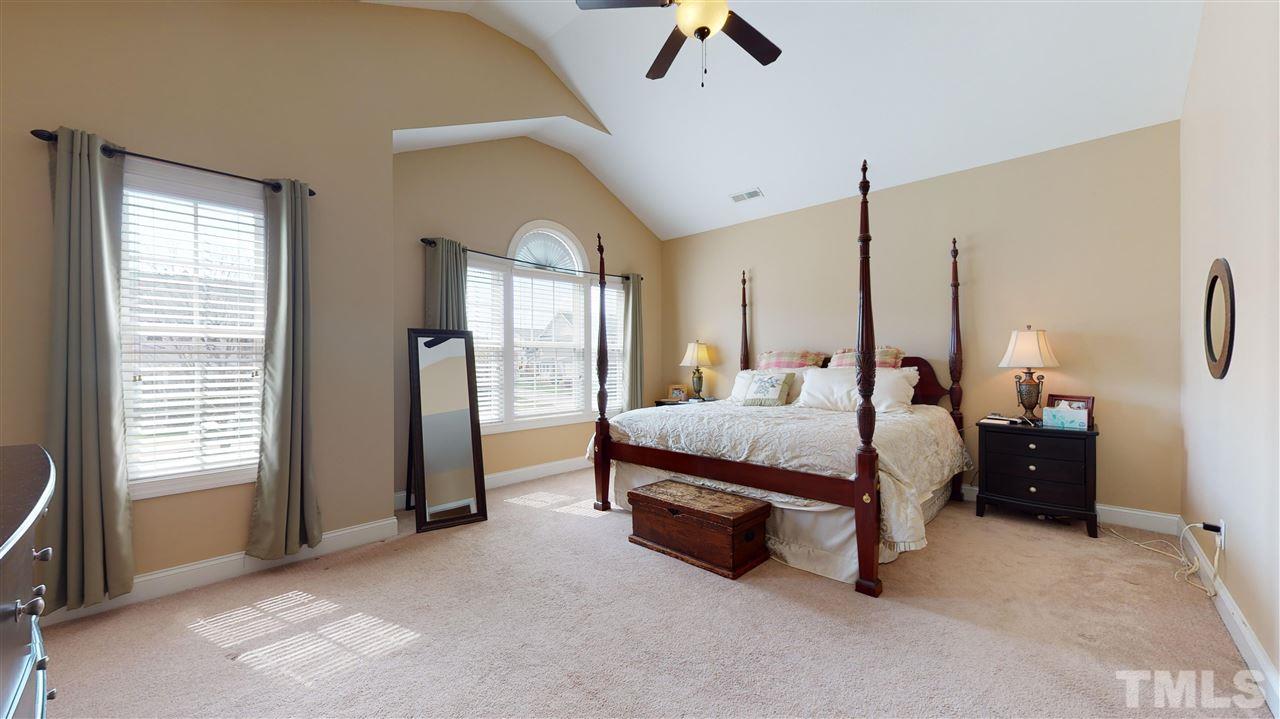 628 Democracy Street Raleigh, NC 27603 - Photo 16 of 26 a bed room with a bed and a chandelier