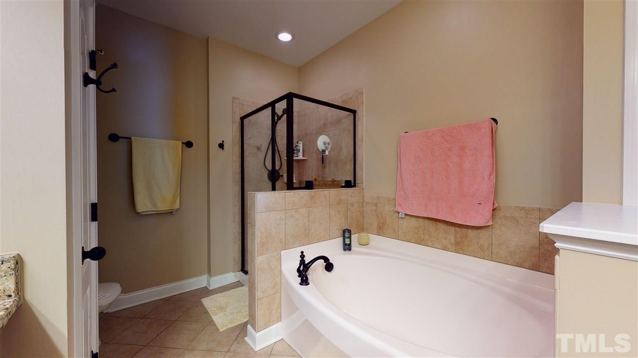 628 Democracy Street Raleigh, NC 27603 - Photo 18 of 26 a bathroom with a tub sink and mirror