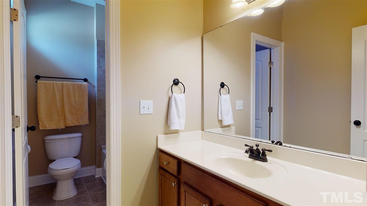 628 Democracy Street Raleigh, NC 27603 - Photo 22 of 26 a bathroom with a sink vanity toilet and shower
