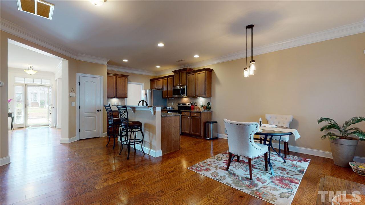 628 Democracy Street Raleigh, NC 27603 - Photo 10 of 26 a kitchen with a table chairs refrigerator and cabinets