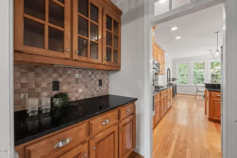 a kitchen with granite countertop a sink stainless steel appliances wooden floor and a counter top space