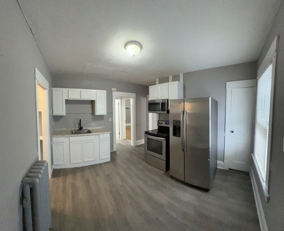 42-44 Narragansett Street, Unit 1 Springfield, MA 01107 - Photo 3 of 10 a kitchen with stainless steel appliances a refrigerator a sink dishwasher a stove top oven a refrigerator and white cabinets