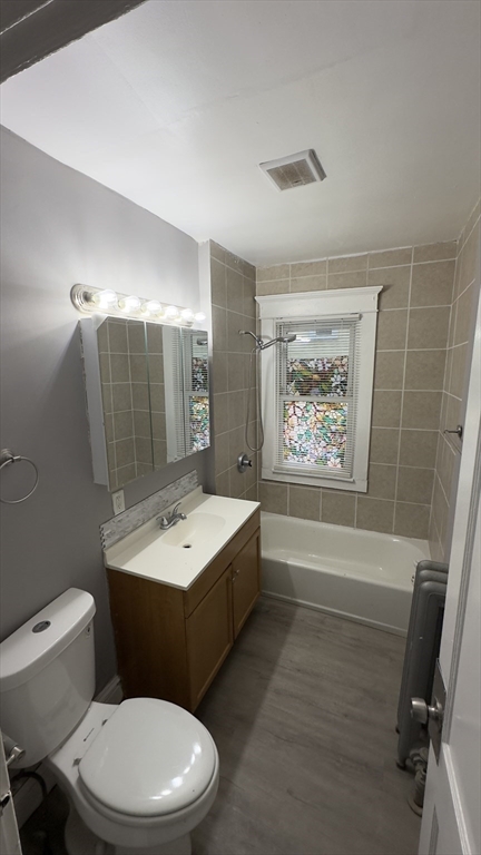 42-44 Narragansett Street, Unit 1 Springfield, MA 01107 - Photo 7 of 10 a bathroom with a toilet a sink and mirror