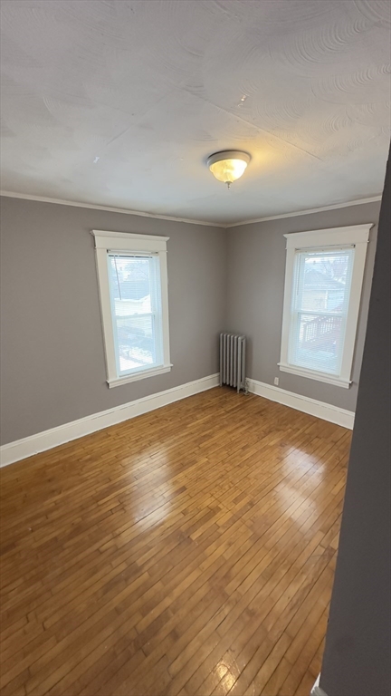 42-44 Narragansett Street, Unit 1 Springfield, MA 01107 - Photo 9 of 10 an empty room with wooden floor and windows