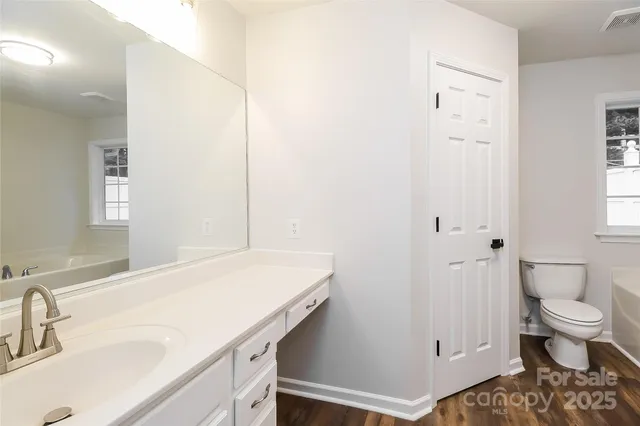 a bathroom with a sink a toilet and a large mirror