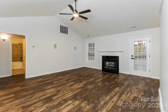 a view of empty room with wooden floor and fireplace
