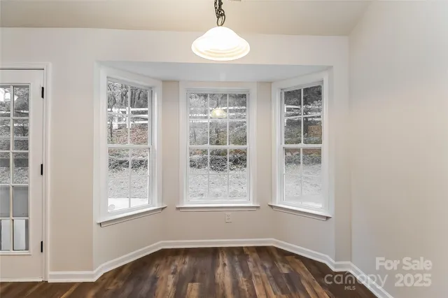 a view of a room with wooden floor and windows