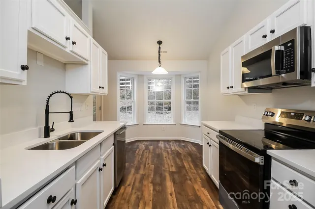 a kitchen with a sink a stove and cabinets