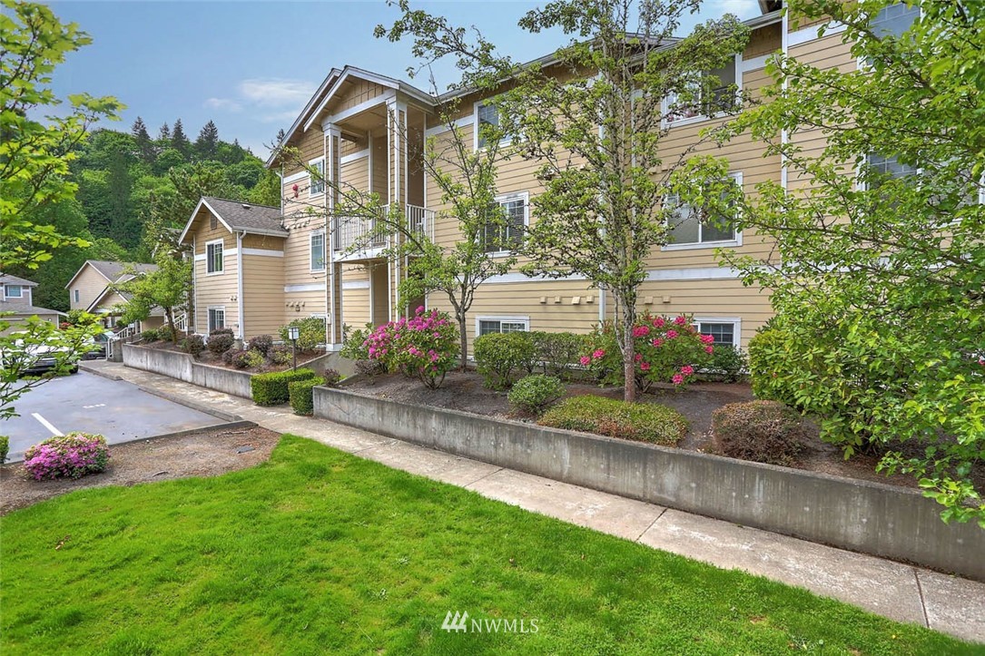 15150 140th Way Southeast, Unit N102 Renton, WA 98058 - Photo 1 of 20 a front view of a house with a yard and lake view