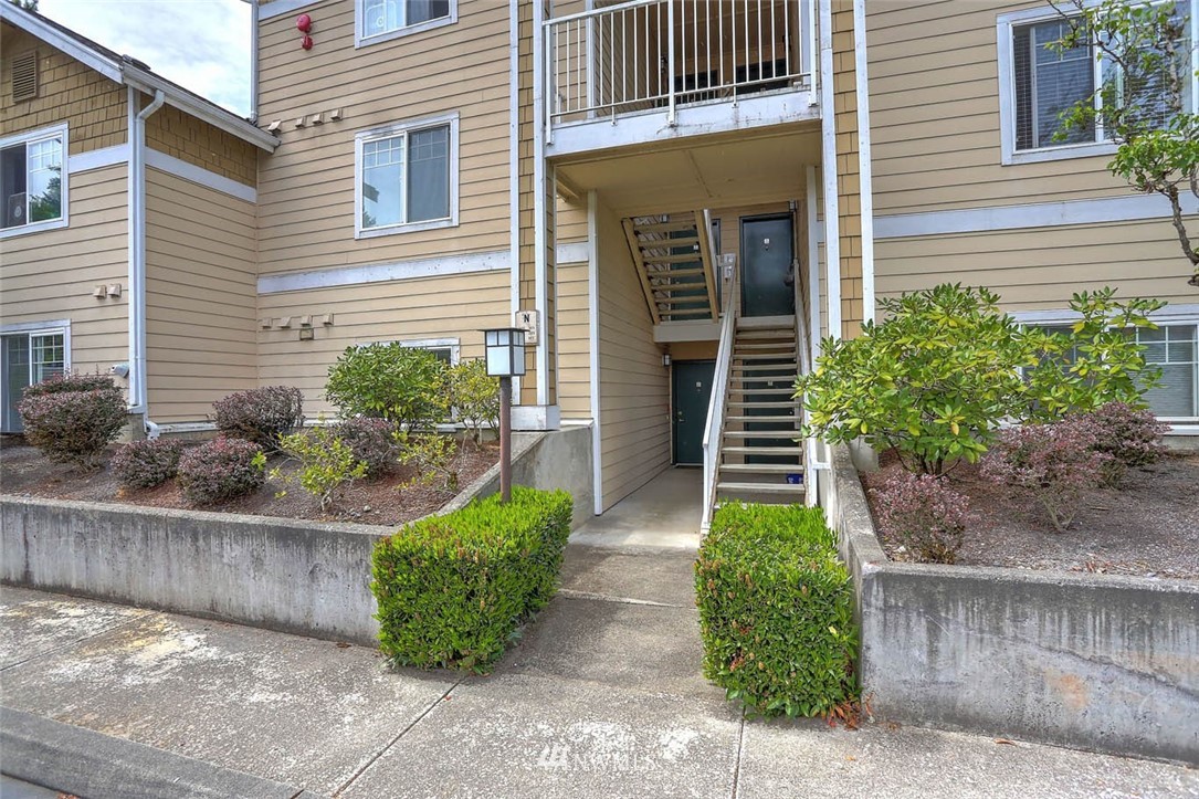 15150 140th Way Southeast, Unit N102 Renton, WA 98058 - Photo 2 of 20 a front view of a house with garden