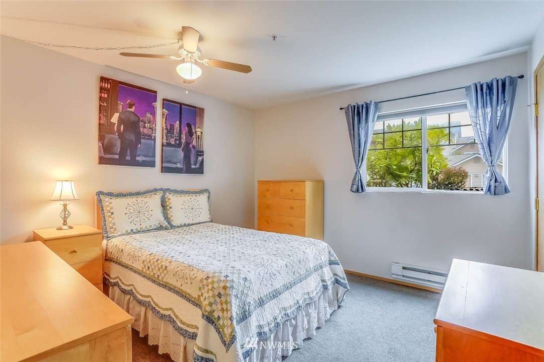 15150 140th Way Southeast, Unit N102 Renton, WA 98058 - Photo 11 of 20 a bedroom with a bed and a chandelier