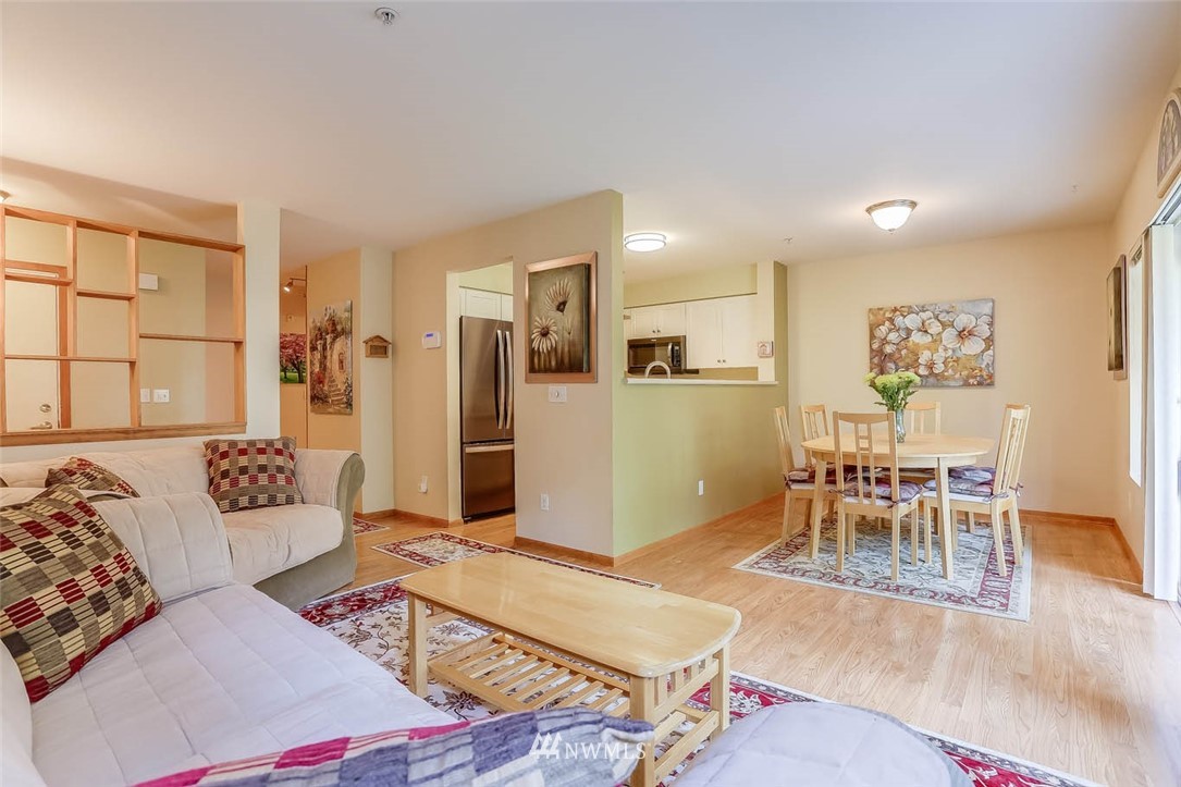 15150 140th Way Southeast, Unit N102 Renton, WA 98058 - Photo 5 of 20 a living room with furniture and a dining table with kitchen view