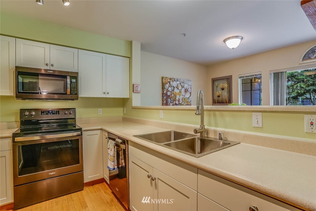 15150 140th Way Southeast, Unit N102 Renton, WA 98058 - Photo 7 of 20 a kitchen with granite countertop a sink and steel appliances