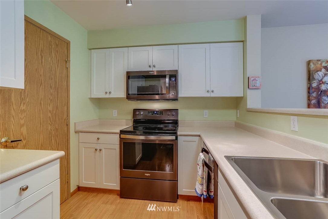 15150 140th Way Southeast, Unit N102 Renton, WA 98058 - Photo 9 of 20 a kitchen with granite countertop a sink a stove and oven