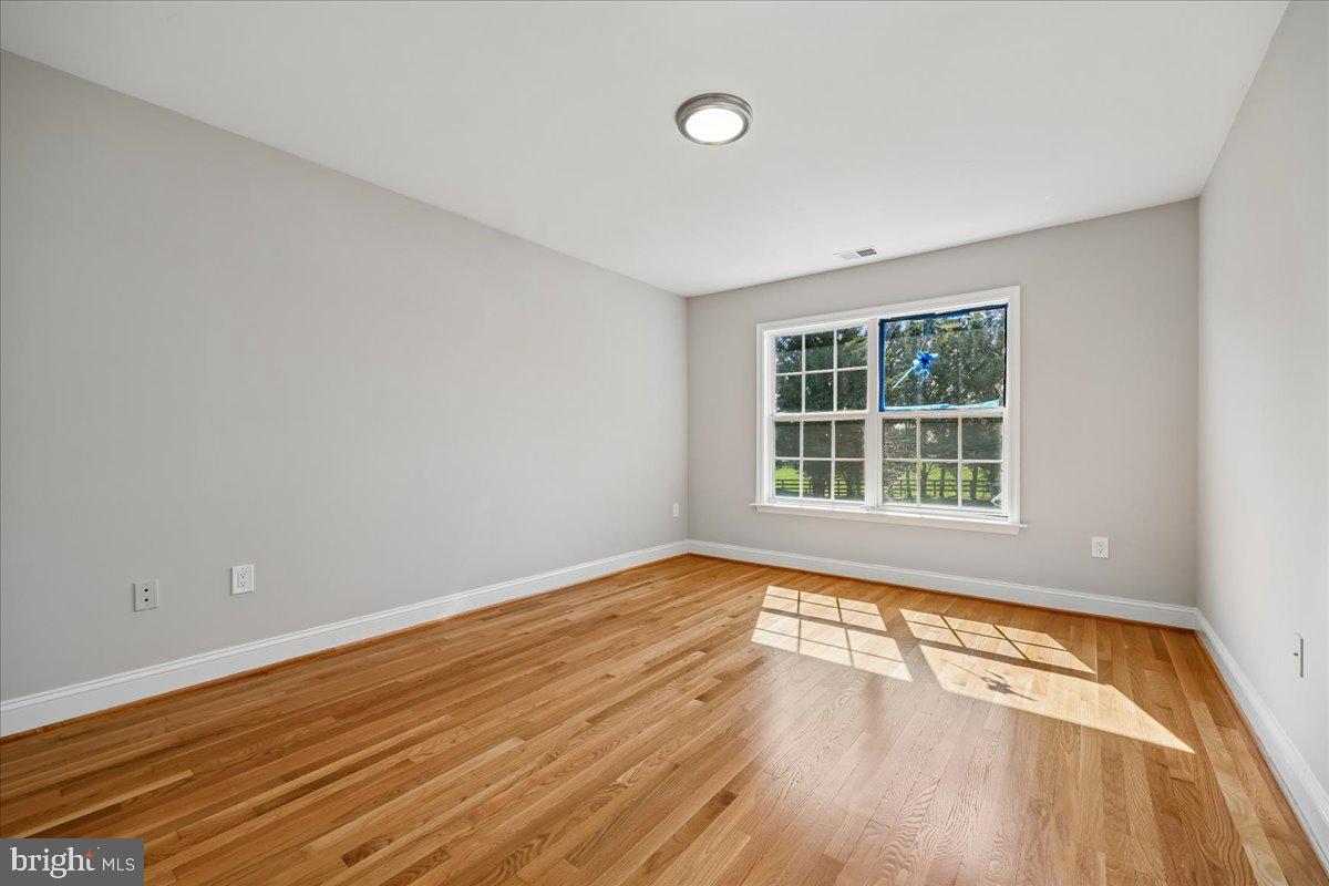 21712 Slidell Road Boyds, MD 20841 - Photo 18 of 32 wooden floor in an empty room with a window