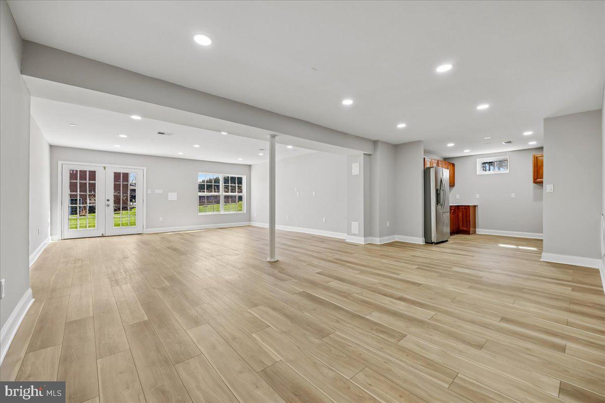 21712 Slidell Road Boyds, MD 20841 - Photo 23 of 32 a view of an empty room with wooden floor and windows