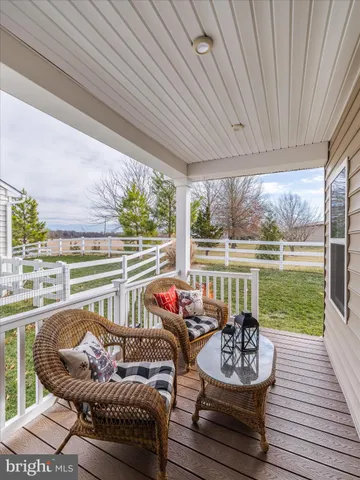 a balcony with furniture and a floor to ceiling window next to a yard