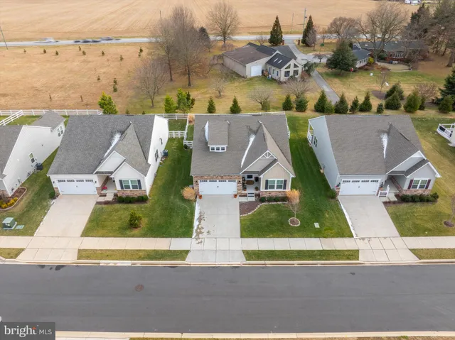 an aerial view of residential houses with outdoor space and ocean view
