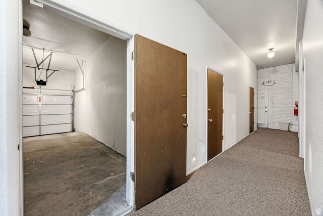 299 West Center Street, Unit 2 Logan, UT 84321 - Photo 29 of 46 Interior hallway with textured carpet flooring, leading to multiple wood-panel doors
