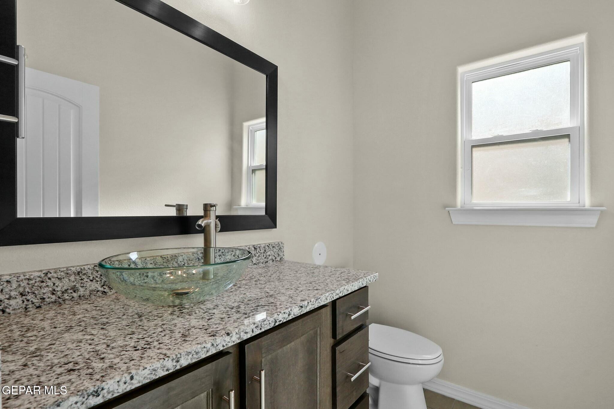 3872 Object Place El Paso, TX 79938 - Photo 16 of 33 a bathroom with a granite countertop sink and a toilet